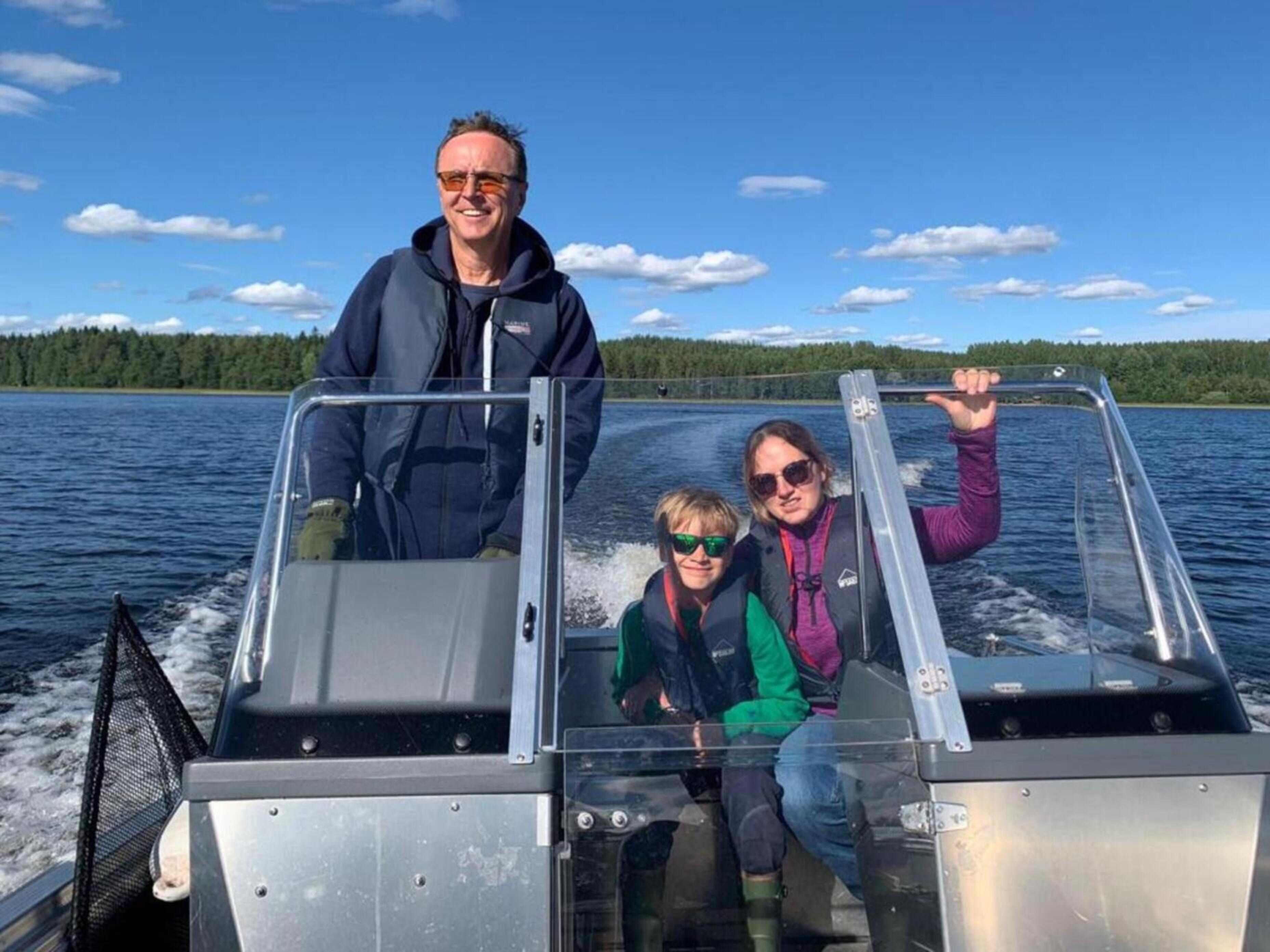 Family on a boat on the Lake Saimaa: vacation in the nature, fishing with the family on the Lake Saimaa, summer on the Lake Saimaa